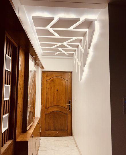ممر بباب خشبي وسقف هندسي مضاء